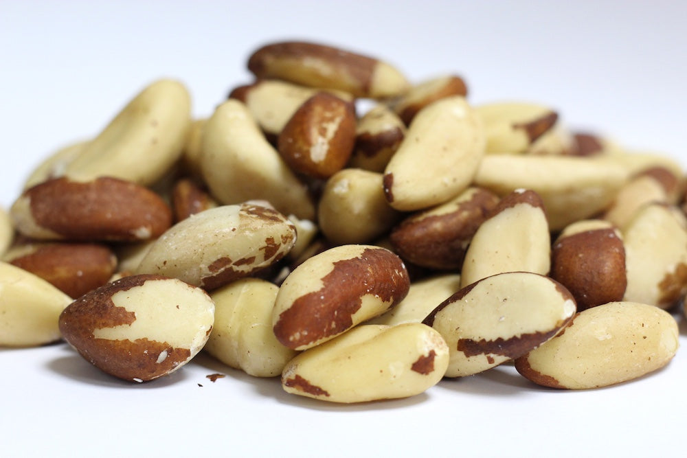 Brazil Nuts, whole creamy beige nuts with smooth, angular surfaces arranged in a loose heap