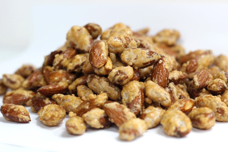 Butter Toffee Almonds: whole roasted almonds coated in golden buttery toffee pieces in a loose pile