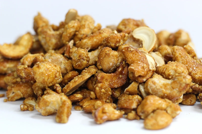 Butter Toffee Cashews, whole cashews coated in crisp golden butter toffee pieces in a loose pile