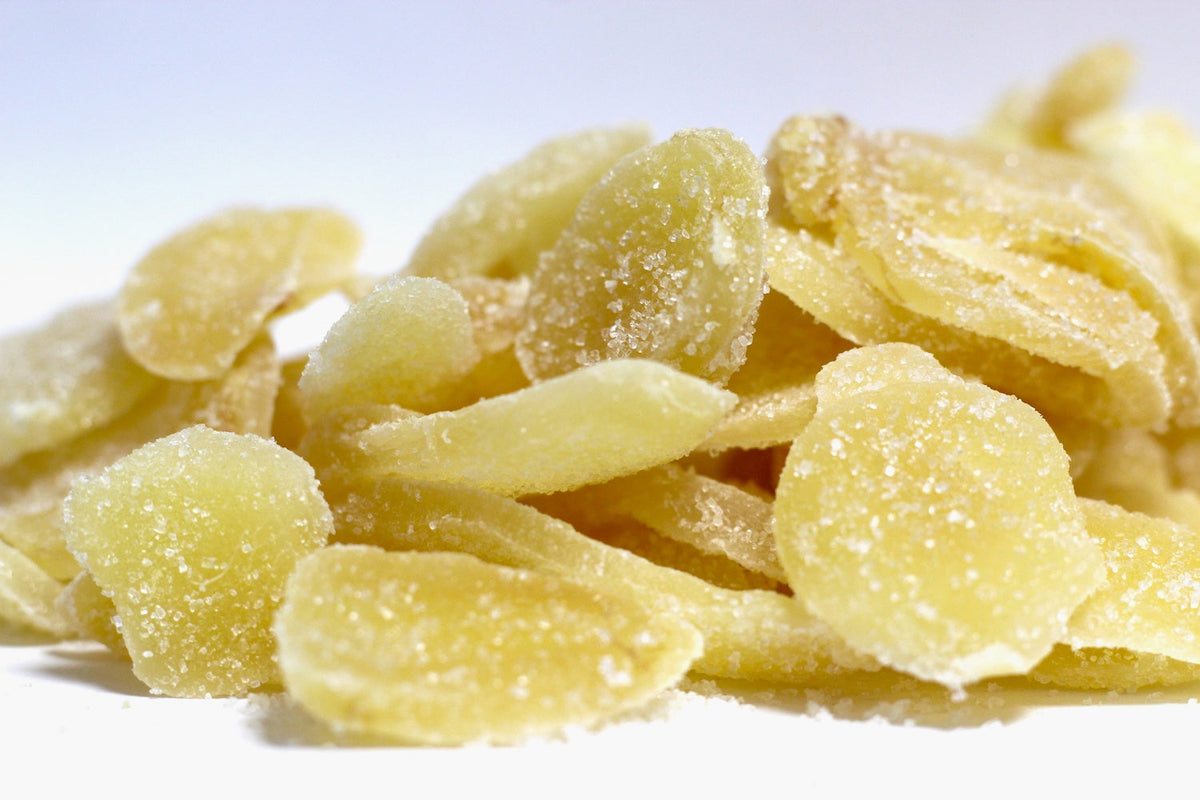 Crystalized Ginger chunks, irregular golden-brown pieces with a sugar-coated surface in a loose pile