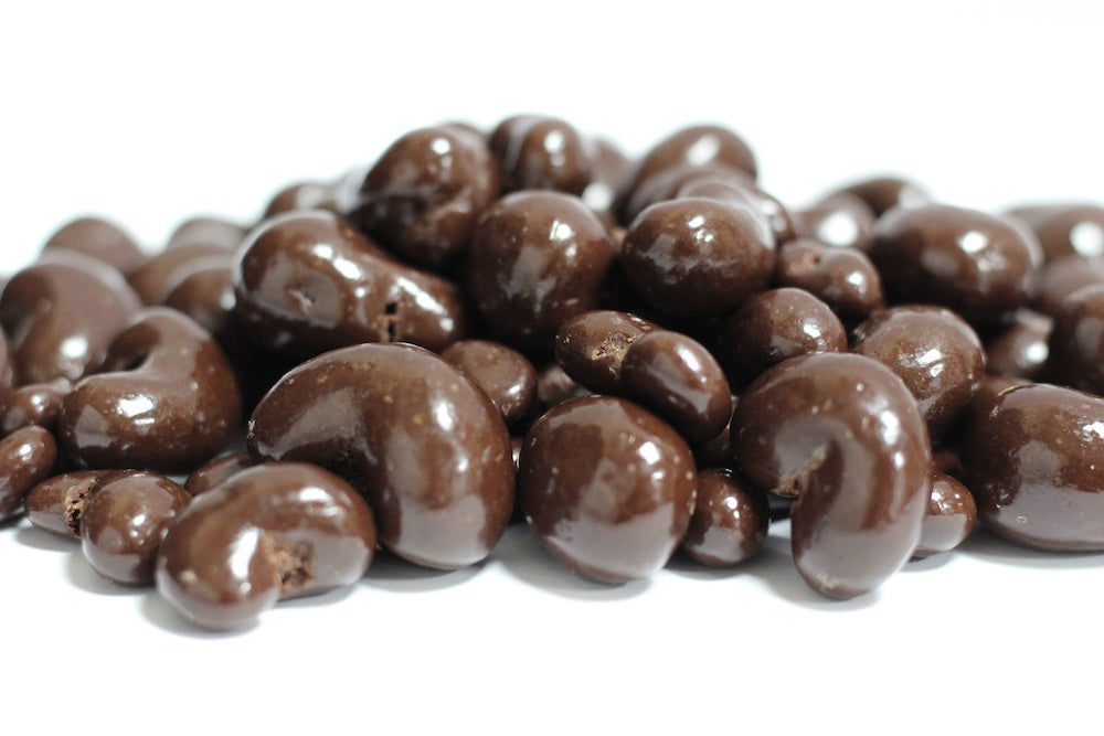 Dark Chocolate Cashews, a loose heap of whole cashews coated in dark chocolate