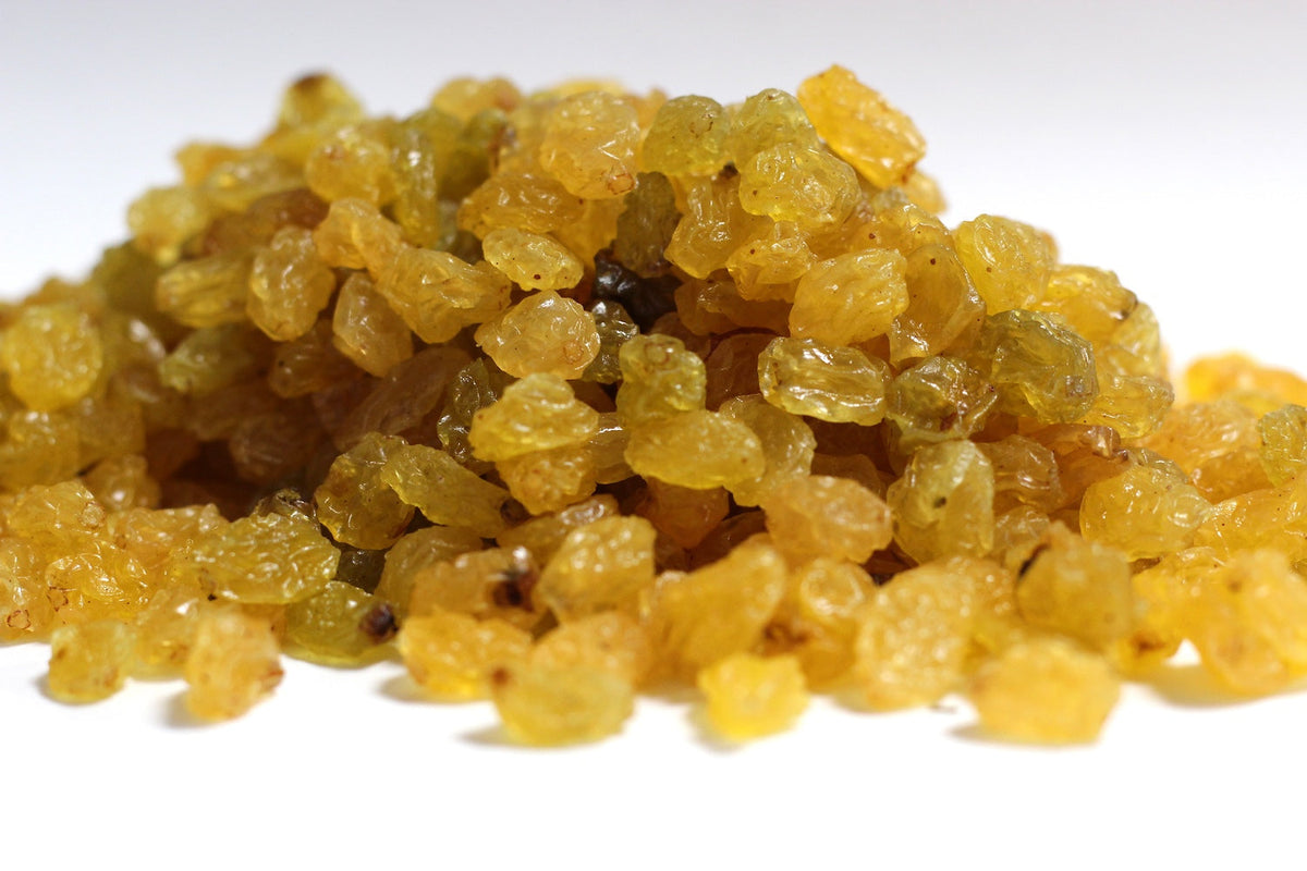 Gold Raisins scattered as whole golden dried grapes in a loose pile