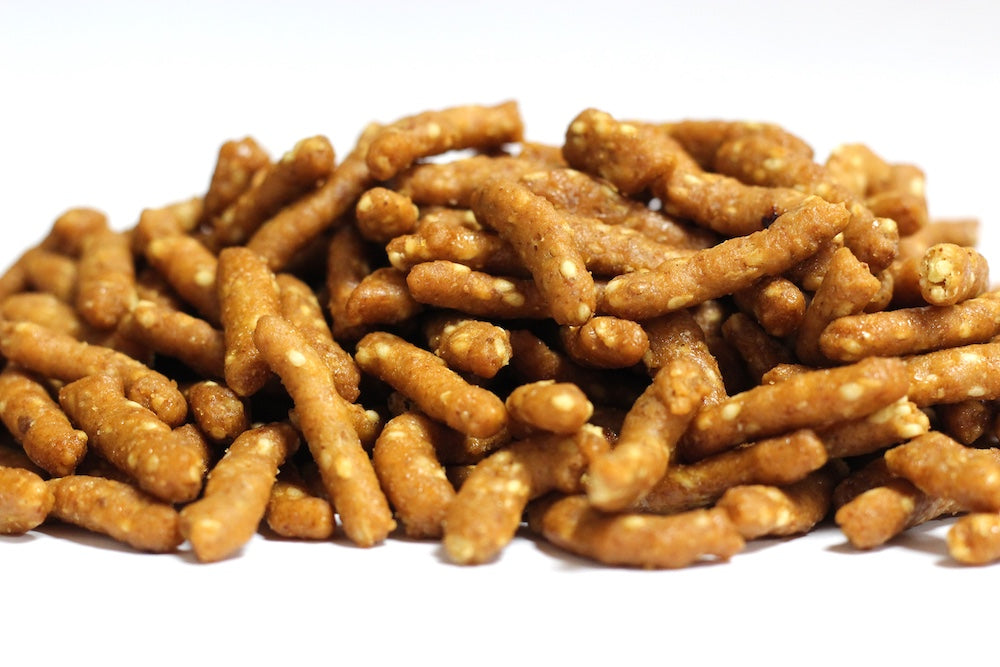 Honey Roasted Sesame Sticks: golden-brown sticks coated with visible sesame seeds and honey glaze in a loose pile
