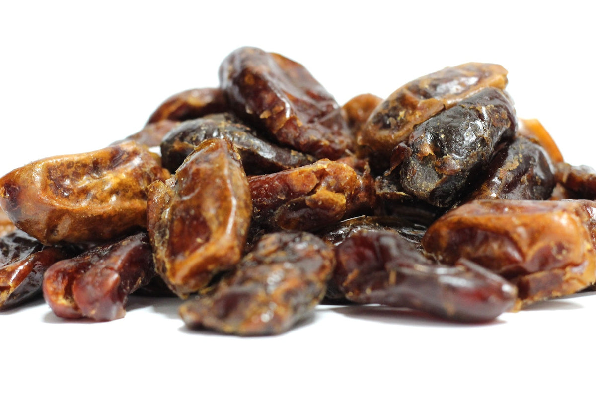 Pitted Dates, whole wrinkled dark brown dates in a loose pile