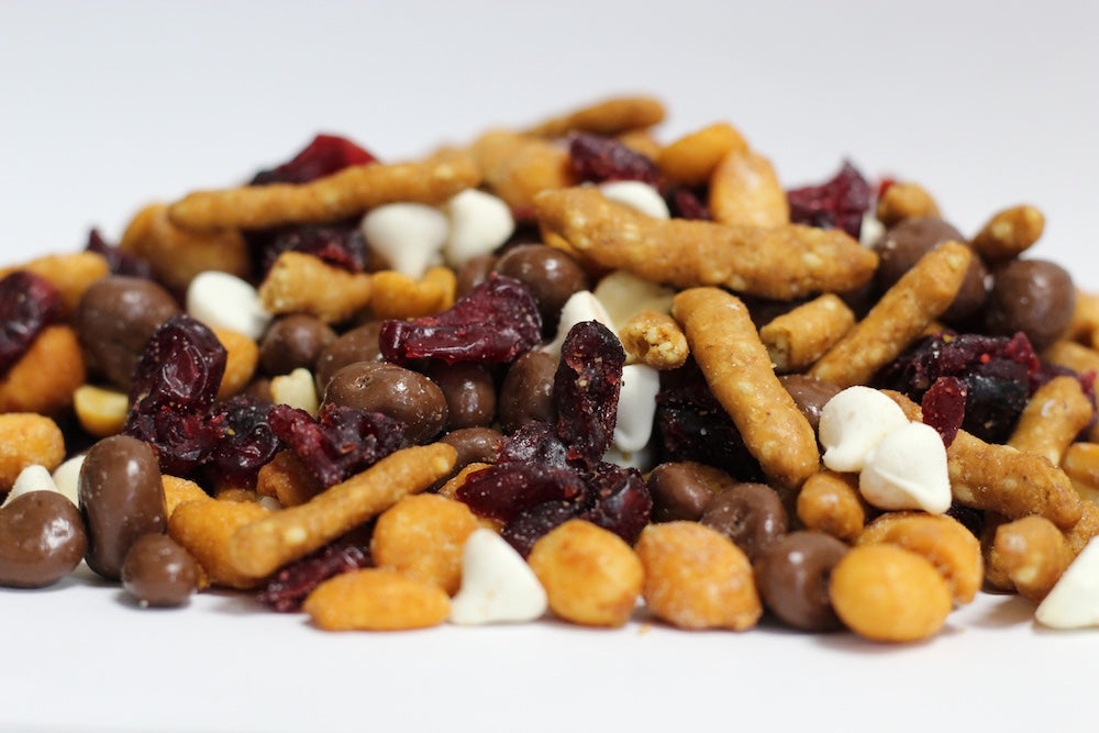 Cranberry Love Fest loose mix of whole dried cranberries, honey roasted peanuts, sesame sticks, and chocolate raisins in a loose pile