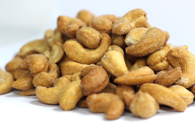 Roasted, Salted Cashews: whole curved cashews with golden-brown roasted surfaces and visible salt in a loose pile