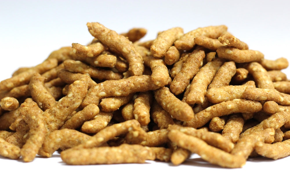 Sesame Sticks, whole golden-brown sticks with visible sesame seeds piled in a loose heap