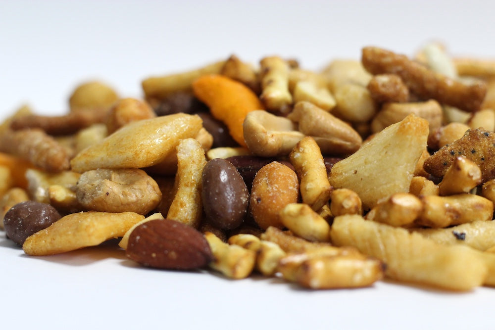 Tailgate Party Crunch loose heap of sesame sticks, milk chocolate raisins, rice pieces and pretzel twists