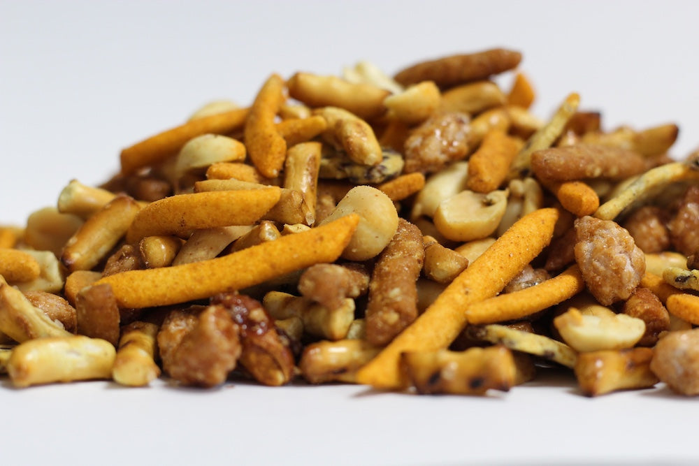 Tempting Tavern Treats, a loose heap of Cajun hot sticks, whole butter-toasted nuts, and salted flax chips