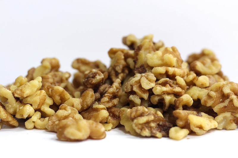 English Walnuts, Halves and Pieces piled loosely, showing crinkled walnut halves and smaller irregular pieces