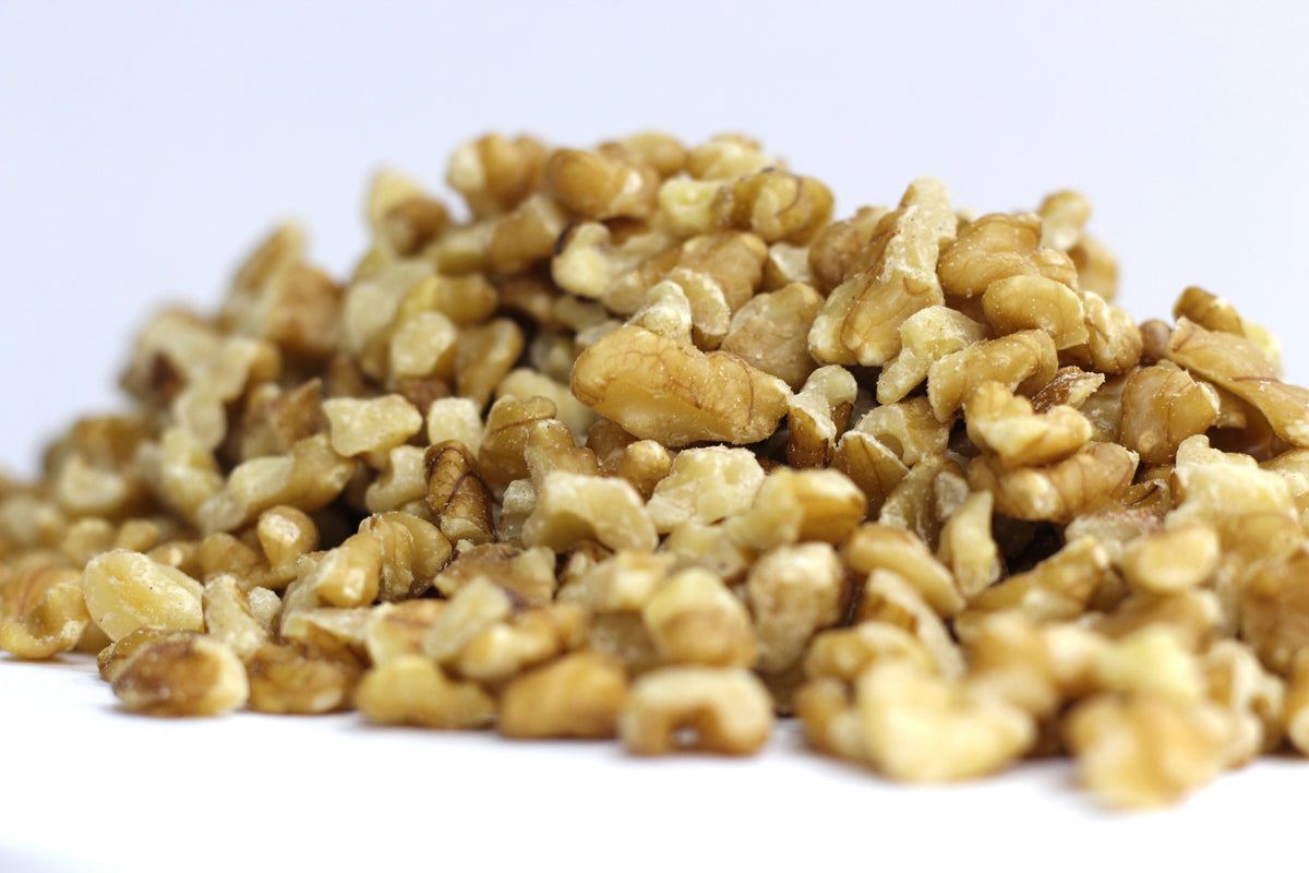 English Walnuts, Small Pieces in a loose heap of irregular, crinkled walnut pieces with light brown interiors